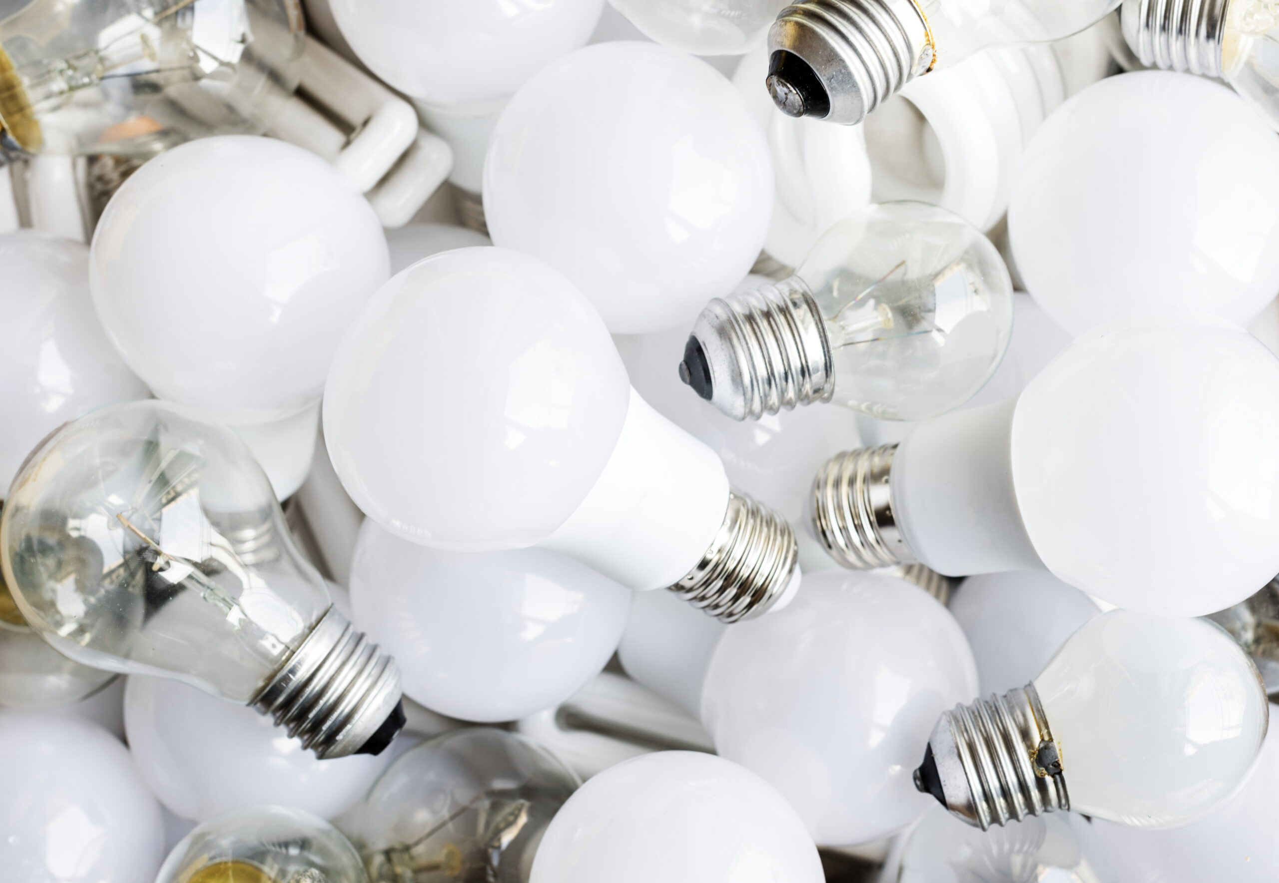 Primo piano di un assortimento di lampadine, che include modelli LED moderni mescolati a lampadine alogene o a incandescenza
